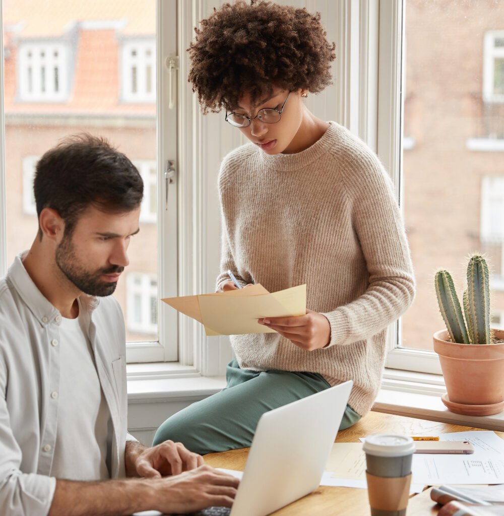 multiethnic-designers-pose-against-window